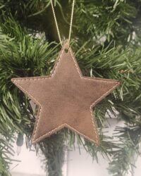 Brown leatherette star ornament with stitched border hanging on Christmas tree branch
