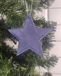 Blue leatherette star ornament with stitched border hanging on Christmas tree branch